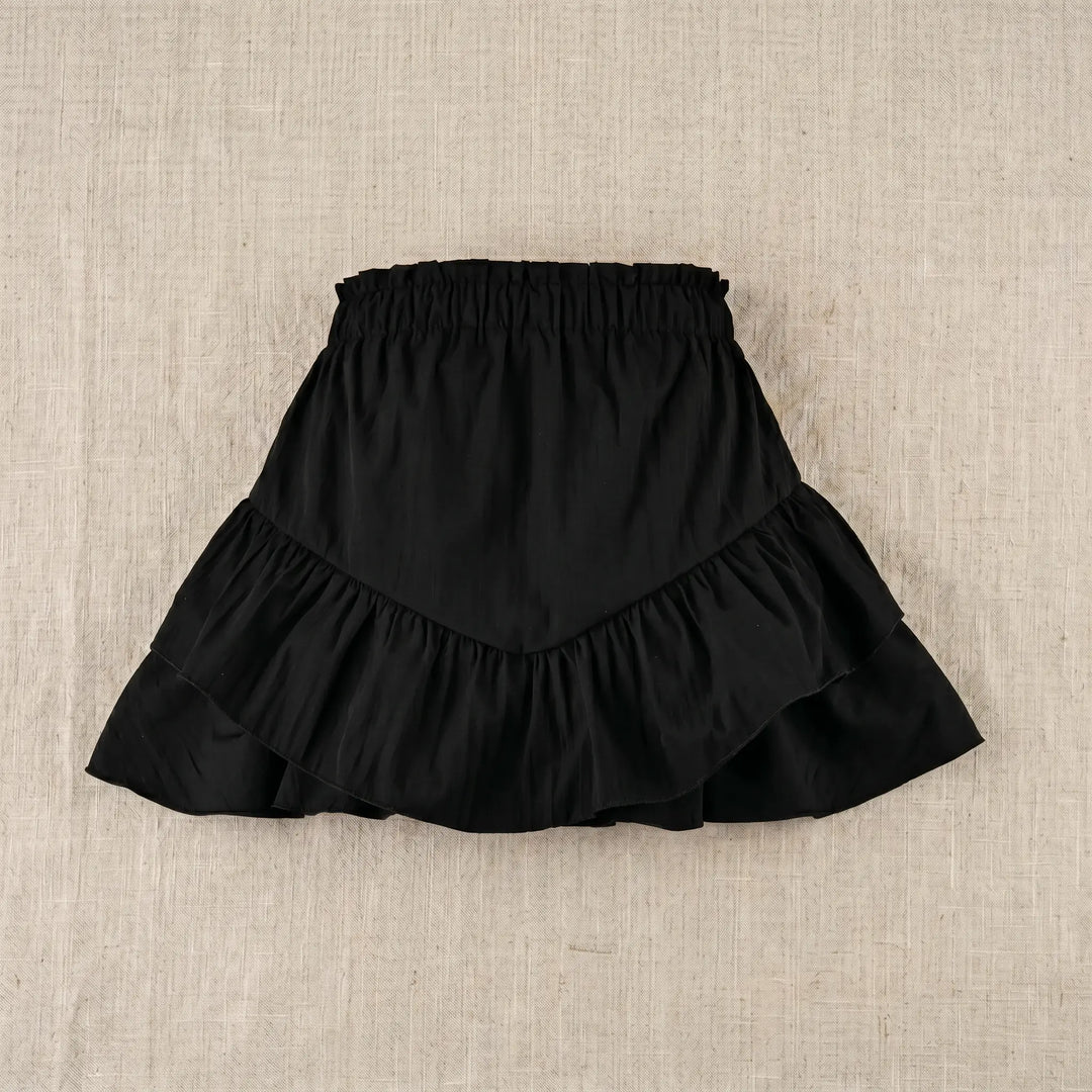 Black mini skirt with high-rise elasticated waistband and two cascading tiers of ruffled fabric, shown flat on a neutral textured background.