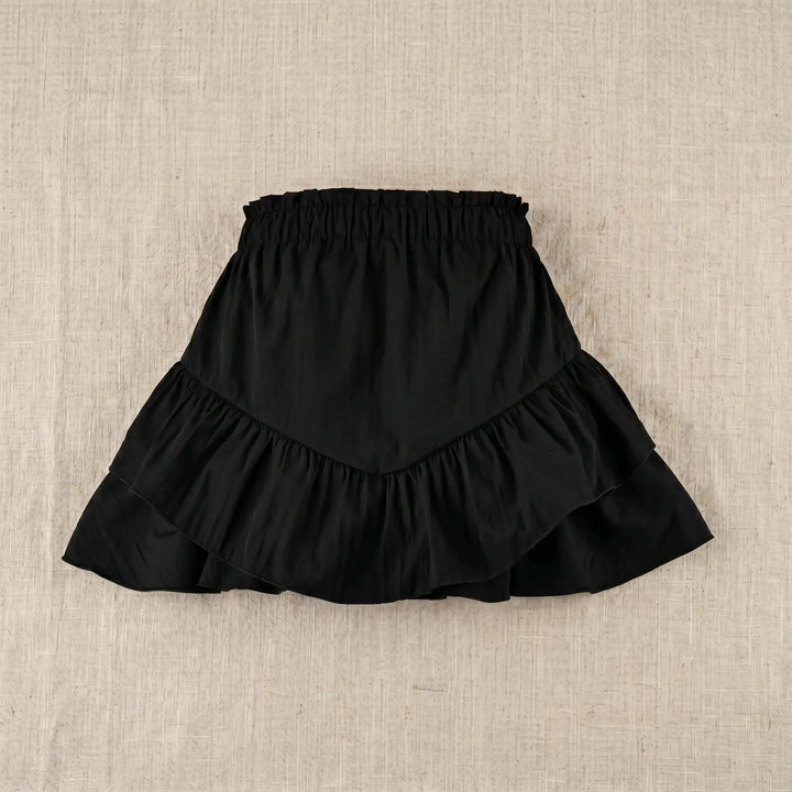 Black mini skirt with high-rise elasticated waistband and two cascading tiers of ruffled fabric, shown flat on a neutral textured background.