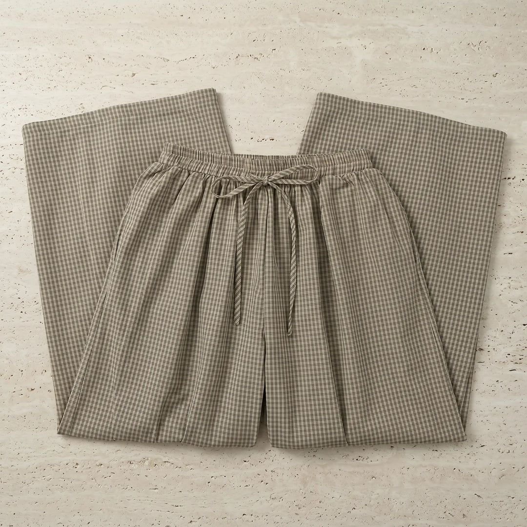 Zelphyr high-rise wide-leg trousers in a fine oat beige plaid pattern, shown laid flat with an elasticated waistband and gathered ankle.
